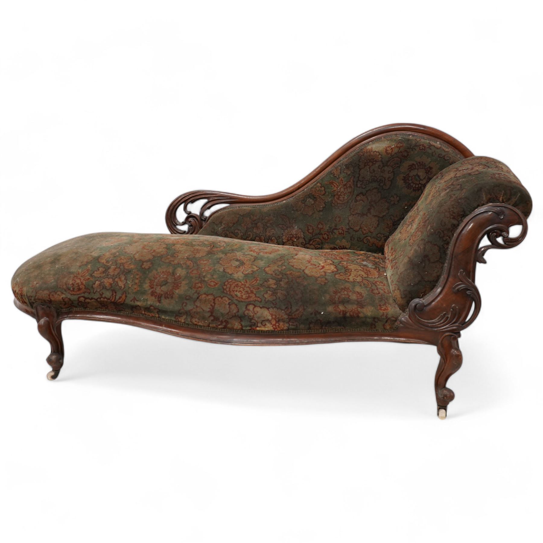 Mid-19th century mahogany chaise longue, shaped and rolled back carved and pierced with scrolling leaf decoration, upholstered in floral pattern fabric, on cabriole feet with brass and ceramic castors