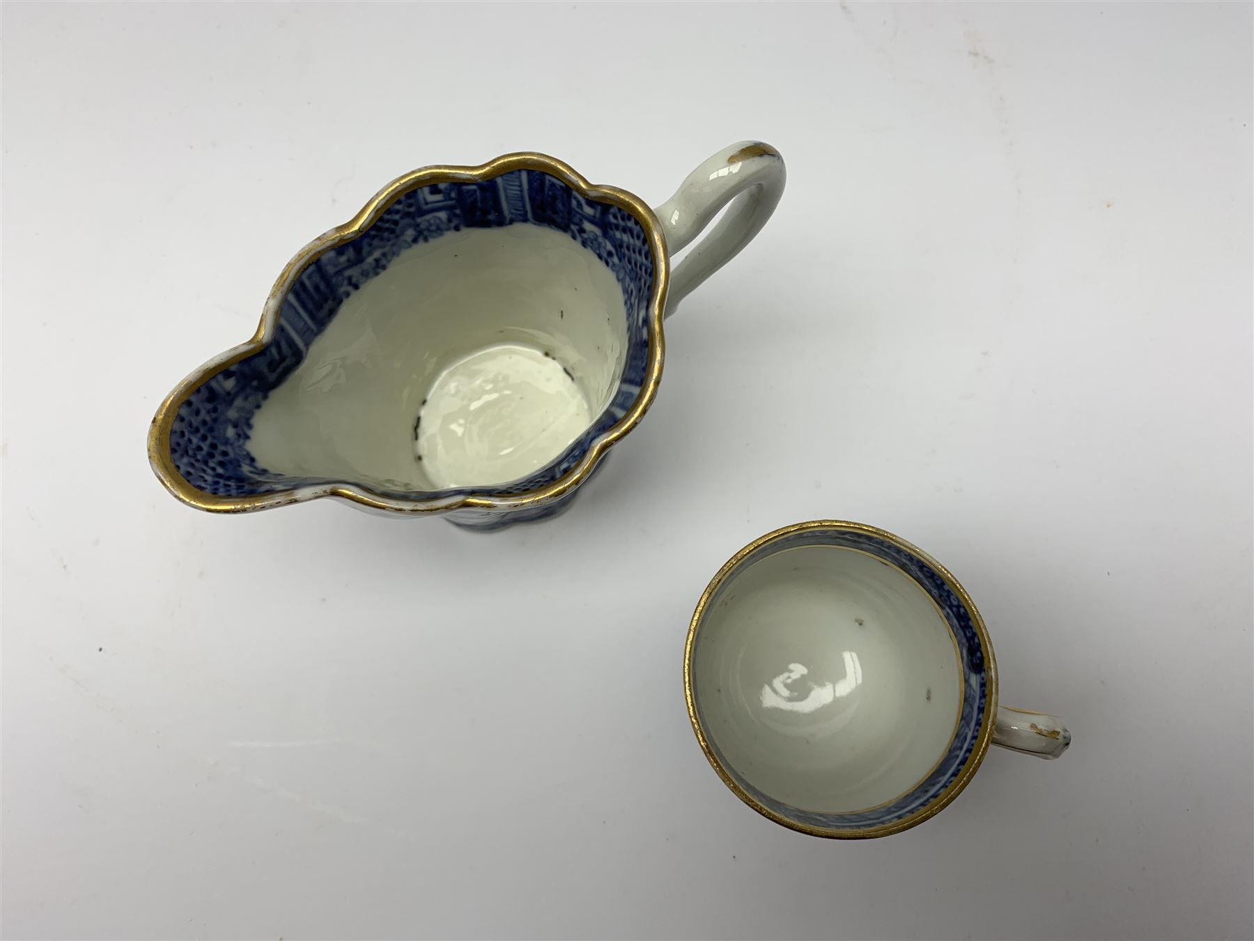 18th century Chinese blue and white porcelain plate, of octagonal form decorated with a riverside scene with pagodas, fence, and trees, within lattice and key fret detailed border, D22.5cm, together with a late 18th/early 19th century blue and white cream boat of English shape, H8.5cm, and an early 19th century Chinese blue and white coffee cup, H6cm, both decorated in riverside scenes 