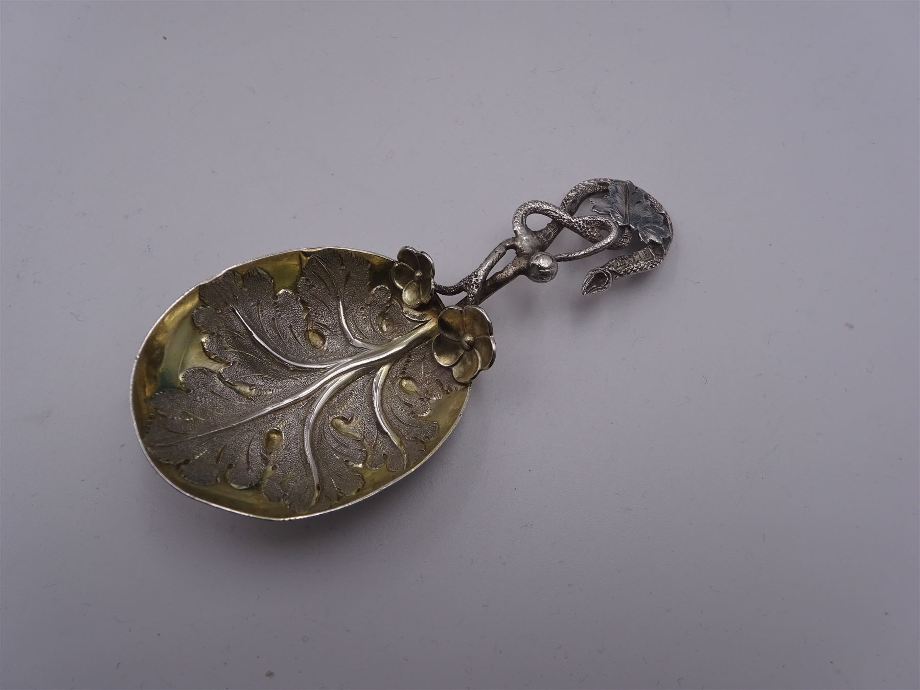 Unusual Victorian silver caddy spoon, the oval parcel gilt bowl embossed with leaf, leading to a flower head mounted tendril handle also detailed with leaf, hallmarked Hilliard & Thomason, Birmingham 1853, L8.5cm, approximate weight 0.49ozt (15.3 grams)