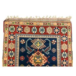 Turkish Anatolian crimson ground rug, the indigo field decorated with five geometric medallions, the guarded border with repeating stylised star symbols 