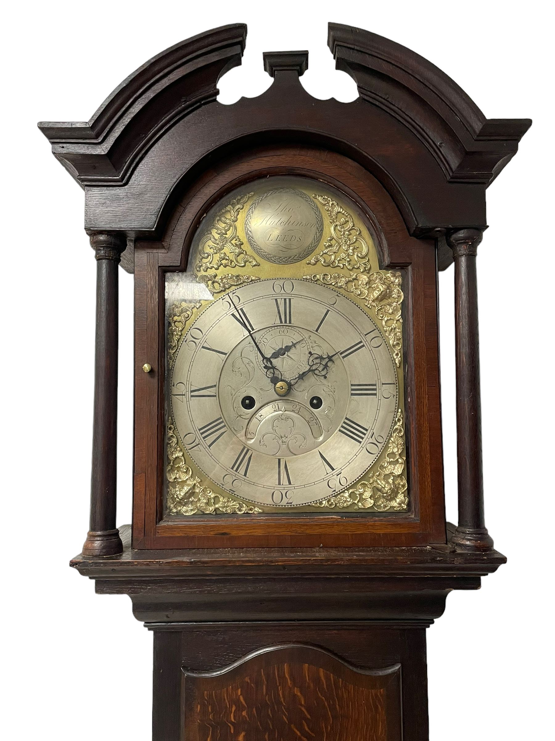 Thomas Hutchinson of Leeds - 18th century 8-day oak longcase clock with as broken arched  pediment and moulded cornice, with a conforming hood door flanked by plain turned pilasters with gesso capitals,  long trunk door with a wavy top on a square plinth with a raised panel, brass dial with cast spandrels,  engraved silvered dial centre and chapter ring with Roman numerals, five minute Arabic's and minute track, with pierced steel hands, seconds pointer,  arched calendar aperture and silvered boss engraved with the makers name to the break arch, dial pinned to a rack striking two train movement with a recoil anchor escapement. With weights and pendulum. Thomas Hutchinson is recorded as working in Leeds from 1760-90.