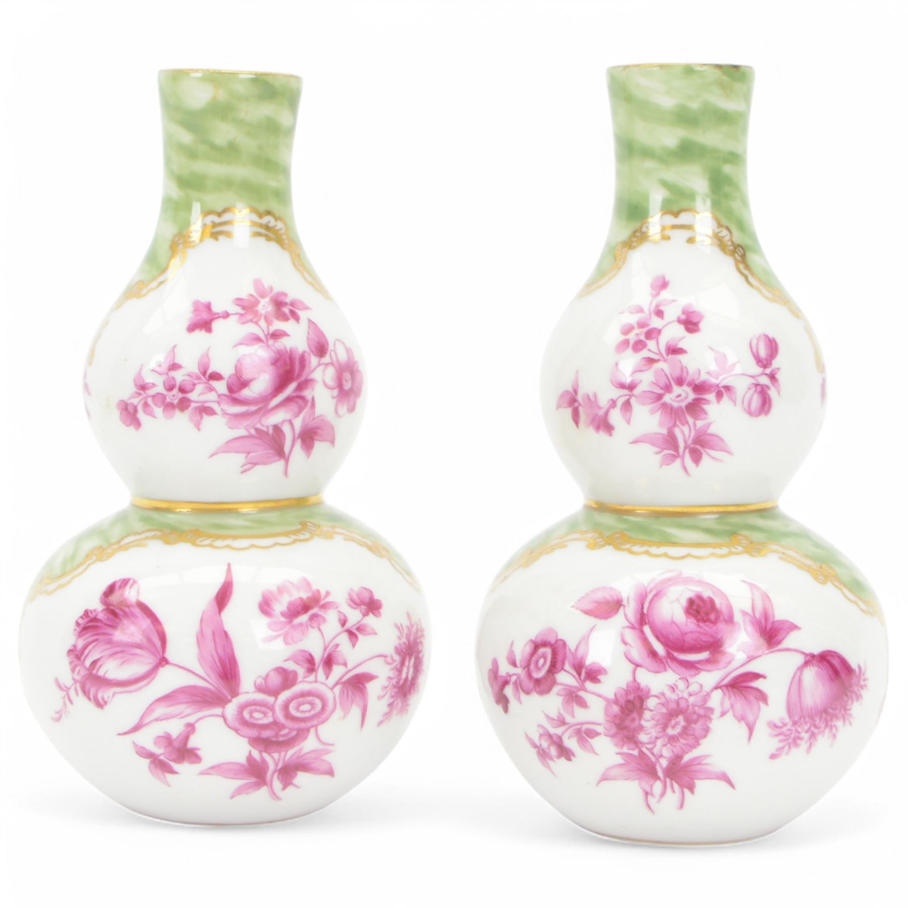 Pair of small late 19th century German double gourd vases, probably Dresden, each hand painted in puce with reserves of a courting couple within a garden setting, and floral sprays upon a white ground, within a green painterly surround, each with very faint traces of blue marks to the unglazed base, H12.5cm