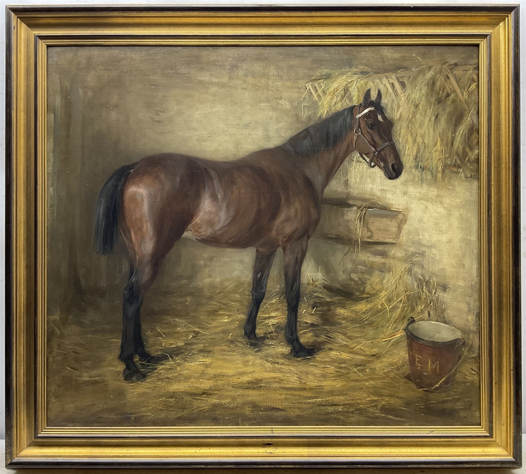 J E M (Early 20th century): Portrait of a Bay Hunter in Stable setting, oil on canvas signed with initials on the water bucket 72cm x 82cm 
