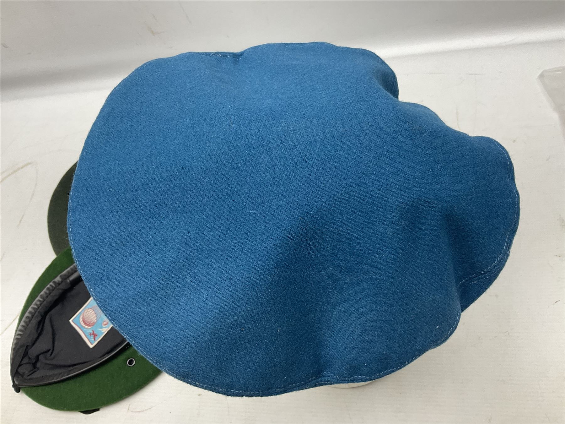 Four paratrooper berets - Russian, Italian, British and Foreign Legion; all with badges (4)