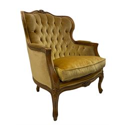 French style beech framed armchair, shaped back carved with flower heads, upholstered in buttoned fabric, cabriole supports 