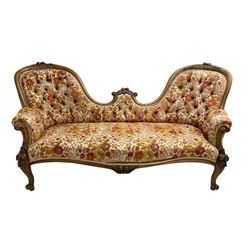 Victorian walnut double ended settee, the shaped and moulded cresting rail carved with fruit and foliage, upholstered in floral pattern fabric, scroll carved arm uprights and supports 