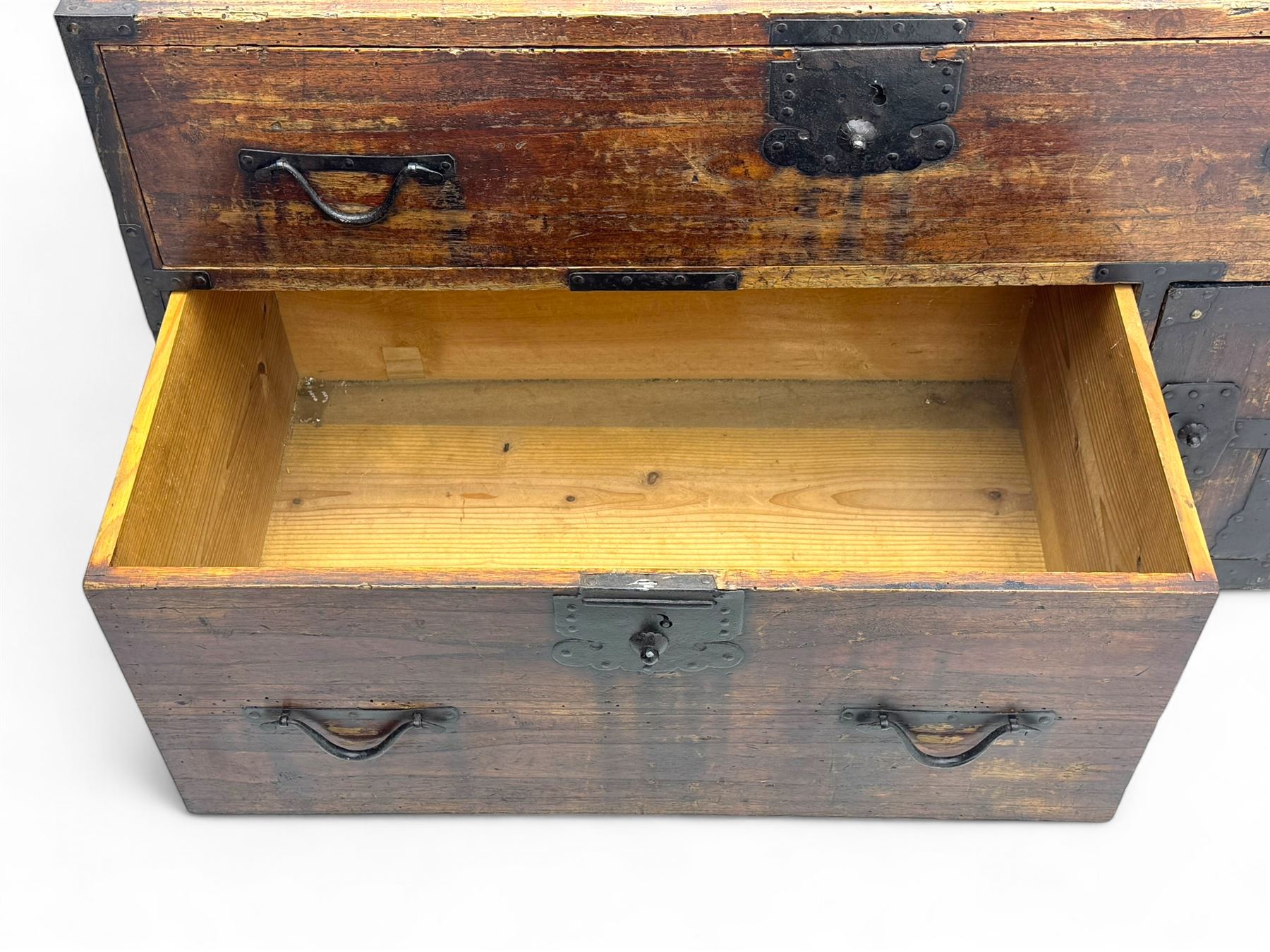 Late 19th century Japanese tansu chest, crafted with a cedar frame and cypress wood panels, original iron fittings throughout, comprising a single long drawer above smaller drawer and hinged cupboard door enclosing two smaller internal drawers and storage compartment, mounted on a bespoke black metal stand