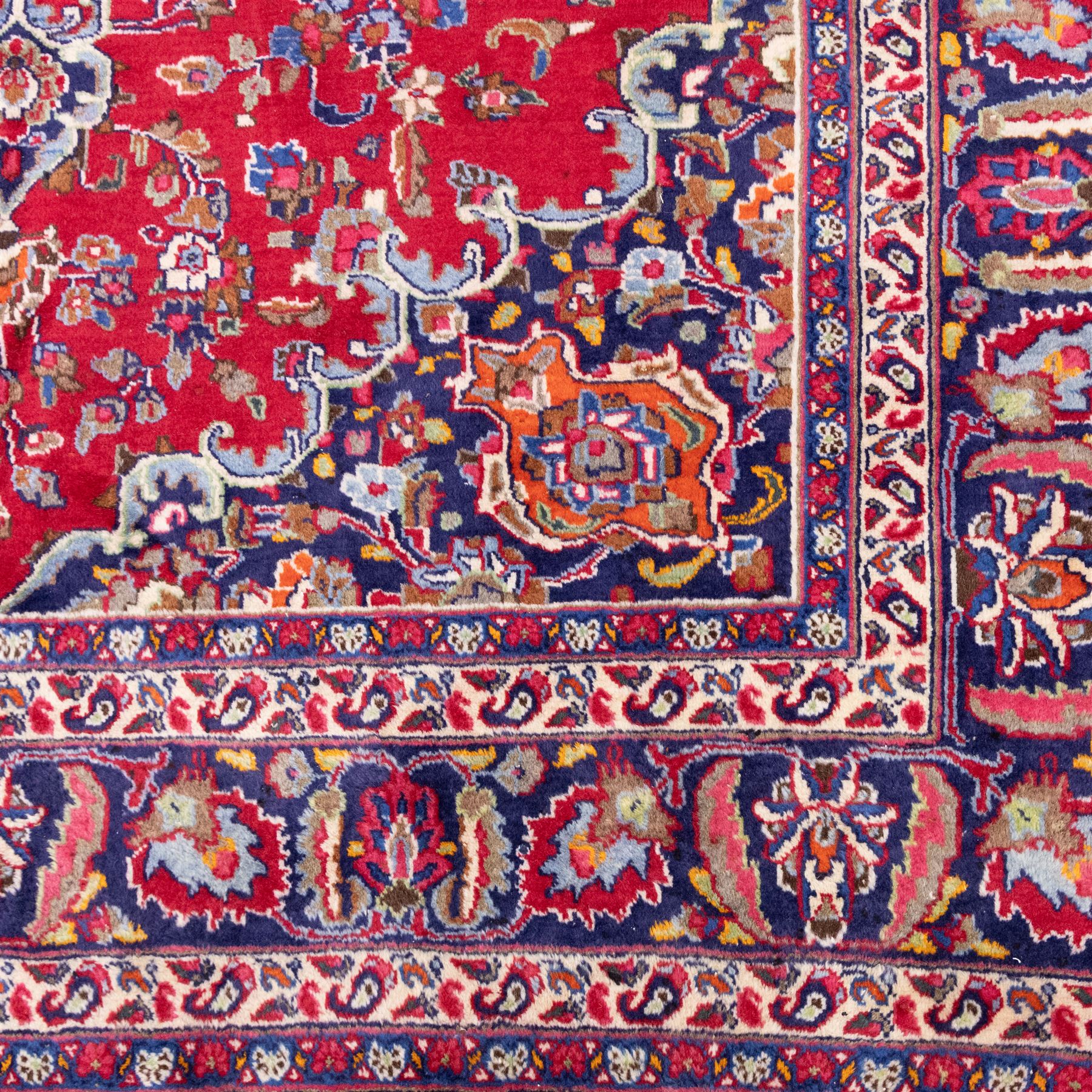 North East Persian Mesued hand-knotted carpet, deep red field with a finely drawn central elongated medallion of navy and ivory, issuing delicate scrolling vines, palmettes and floral sprays in a dense all-over composition, main border on dark ground decorated with a continuous palmette and vine scroll, flanked by multiple narrow guard stripes incorporating rosettes and stylized floral devices, with cotton fringe ends 