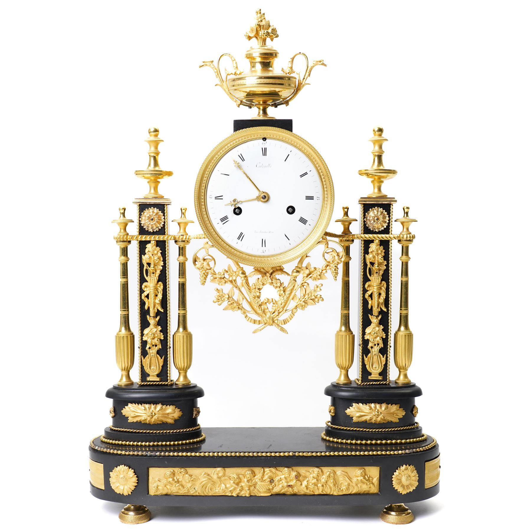 French-Early 19th century 8-day ormolu and polished black slate portico clock, case surmounted with a twin handled urn with flowers, supported by two square pedestals with finials and trailing floral mounts on oval bases, raised on an oval plinth with toupie feet, enamel dial signed 