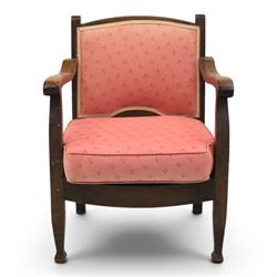 Early 20th century small oak open armchair, arched upholstered back with brass stud border over shaped seat cushion upholstered in pink foliate fabric, shaped open arms on square supports