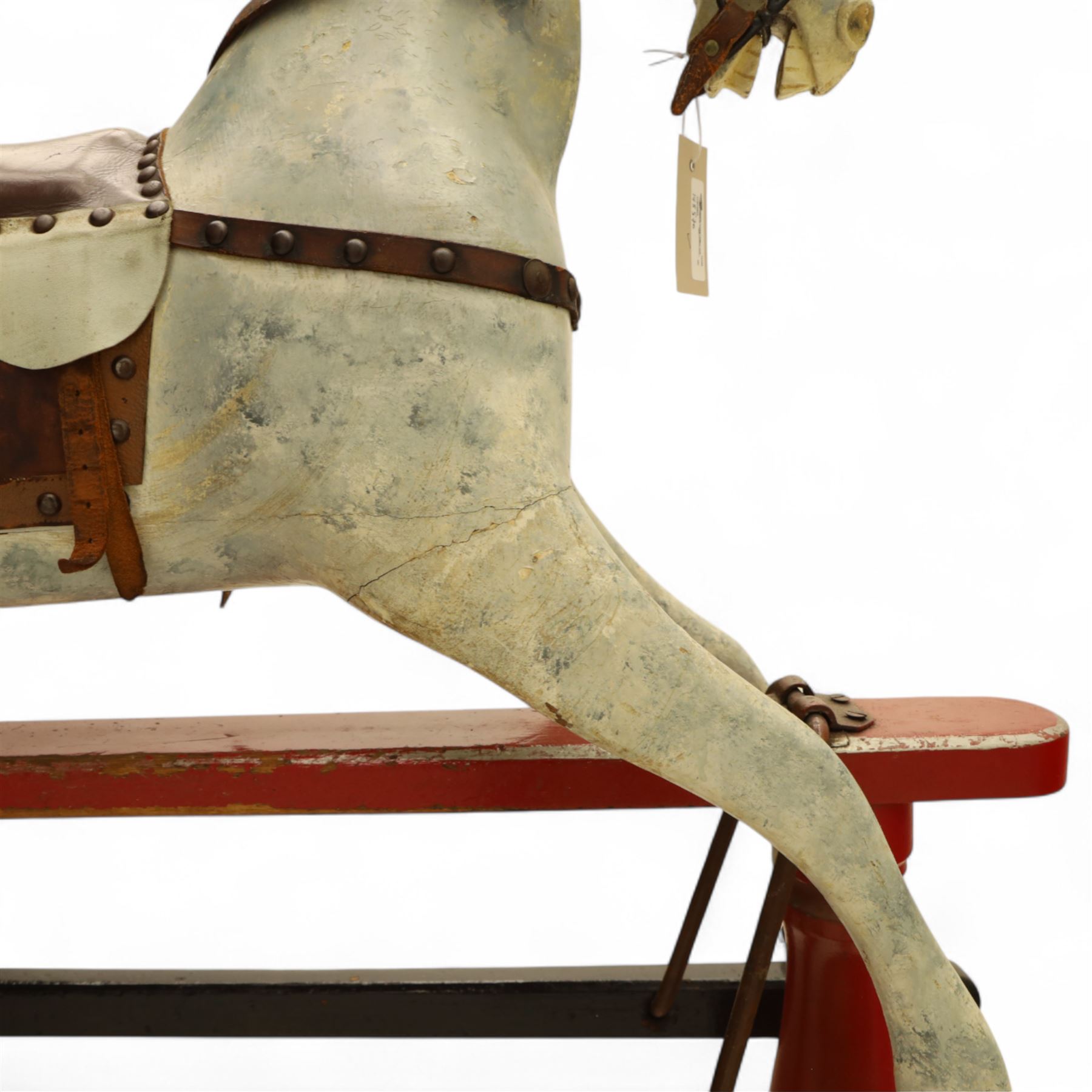 20th century carved and painted rocking horse, with original dappled paint finish, studded leather saddle and reins, on later red and black swing frame