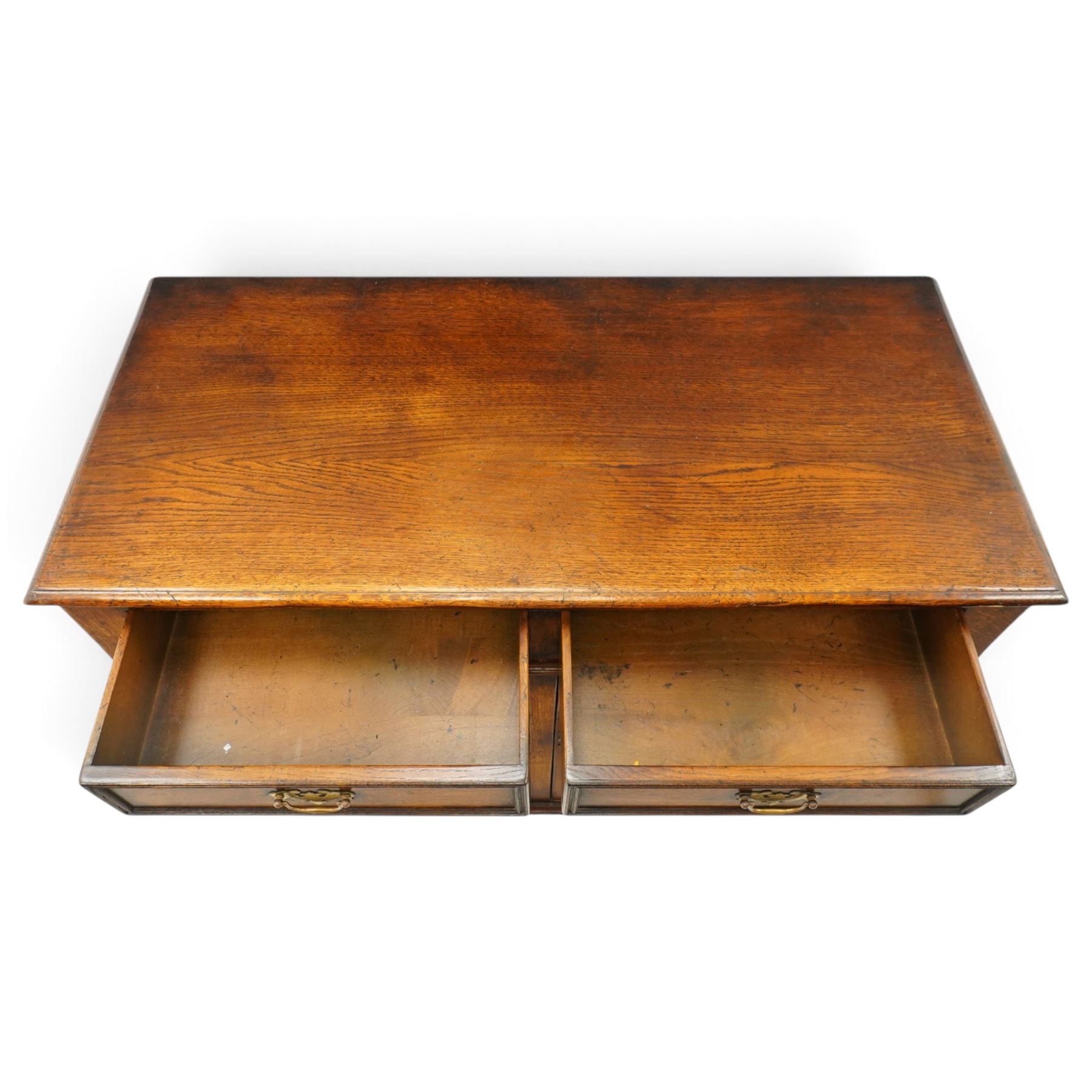 18th century style oak dresser base, rectangular moulded top over two frieze drawers with brass handles, twin panelled cupboard doors below with pierced brass escutcheons, on stile feet