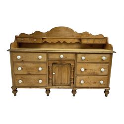Victorian pine dresser, shaped raised back with small drawers, fitted with seven drawers and central panelled cupboards, on turned feet