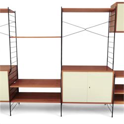 WHB - 'Ladderax' 1960s German modular shelving wall unit, comprising two teak cabinets with white doors, a further fall front teak cabinet with white front, a drawer section with three drawers with recessed handles, multiple shelving sections, raised on metal ladder frames, with further spare sections

Cabinet units: H 47cm, D 36cm, W 71cm
Fall front unit: H 40cm, D 26cm, W 71cm
Shelve widths: 50cm, 71cm 
Shelve depths: 26cm, 36cm