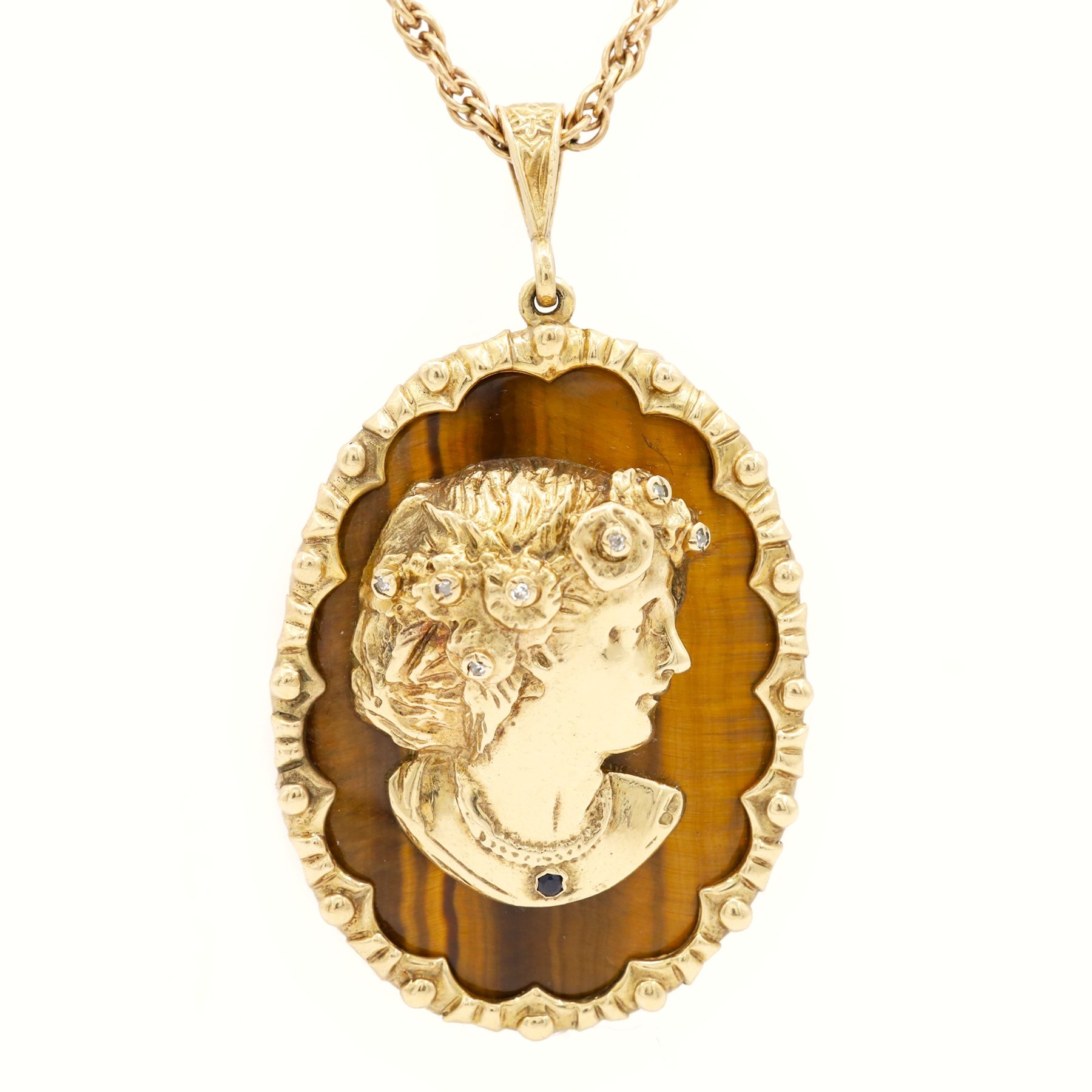 9ct gold tiger's eye diamond and sapphire portrait pendant necklace, oval cut tiger's eye, with applied bust of a lady in profile, her hair set with diamonds and necklace set with a sapphire, within a scalloped design frame, on a fancy twist chain necklace, both hallmarked