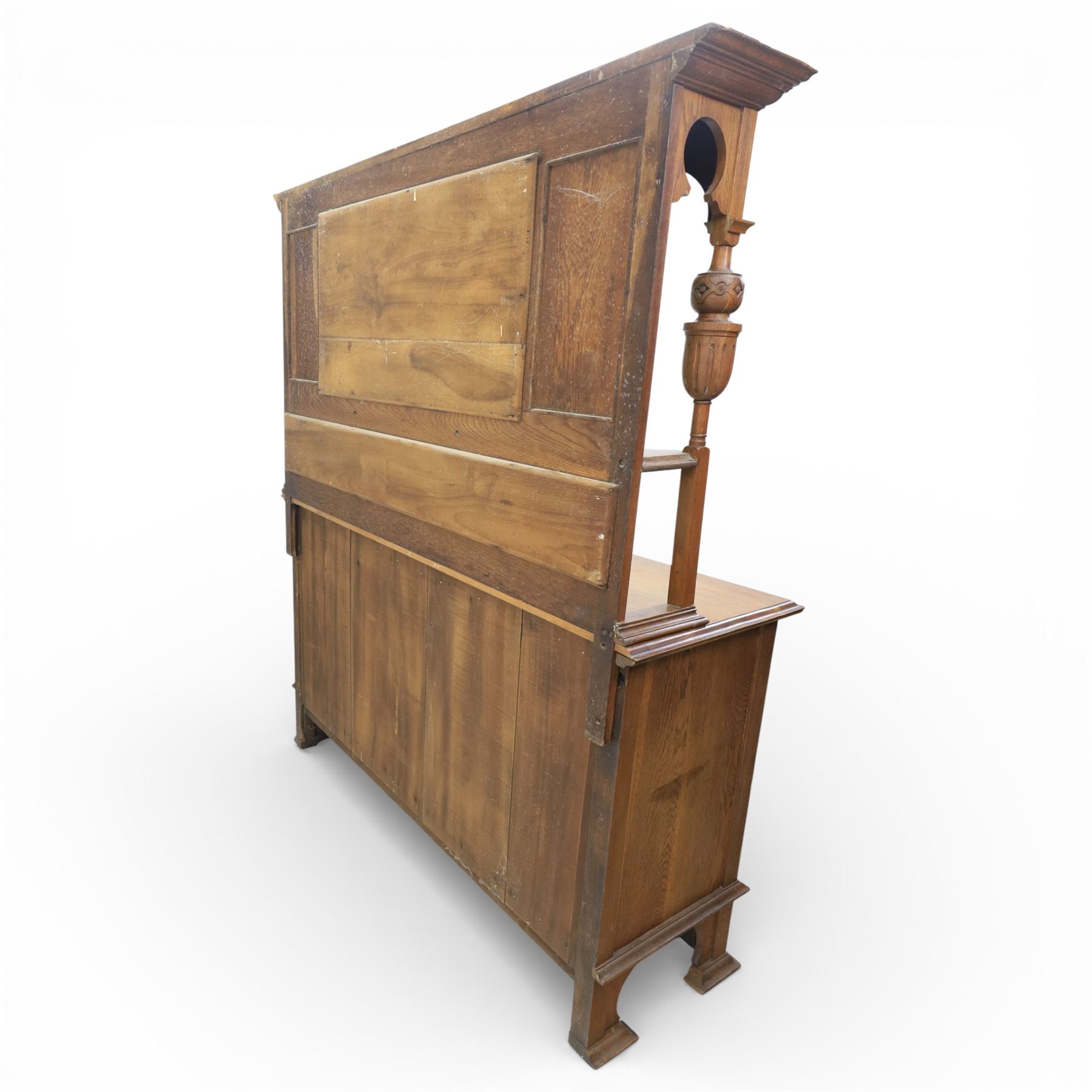 Arts and Crafts oak mirror back sideboard, the bevelled rectangular mirror set within a back with foliate carved panels, with turned baluster and knopped supports, upon a base with moulded top above three drawers  and three cupboard doors, two with carved foliate detail, upon four shaped bracket feet