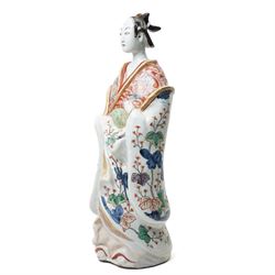 Large Japanese Imari porcelain figure, modelled as a Bijin, wearing a long kimono decorated with apple blossom and leafy branches on a white ground, with gilt detailing, possibly Edo period, H63cm
