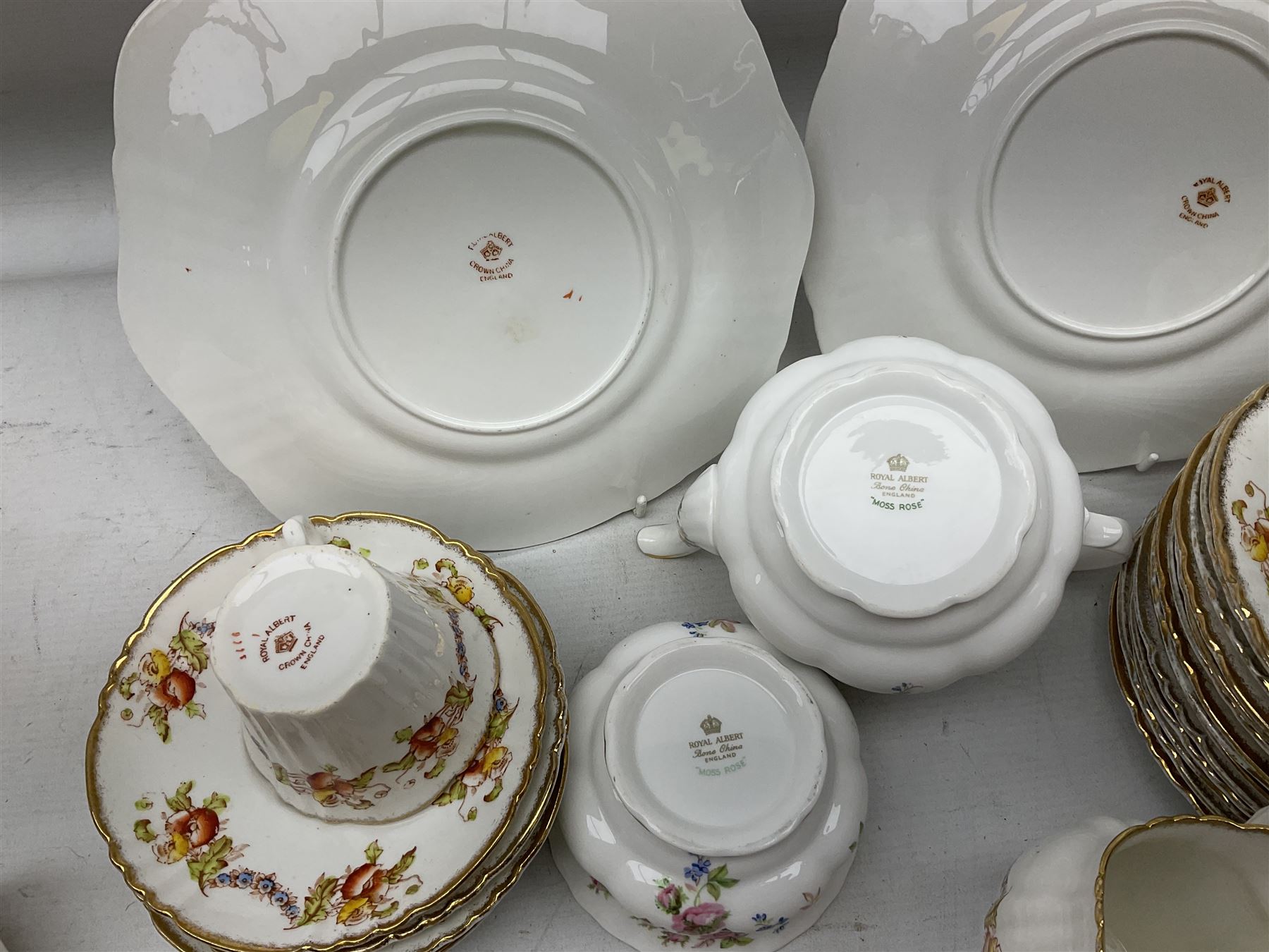 Quantity of Royal Albert tea wares to include 'Moss Rose' teapot, sucrier and saucers, together with teacups, saucers, side plates, jug etc decorated with orange, yellow and blue floral sprays with gilding upon plain ground, all stamped Royal Albert beneath