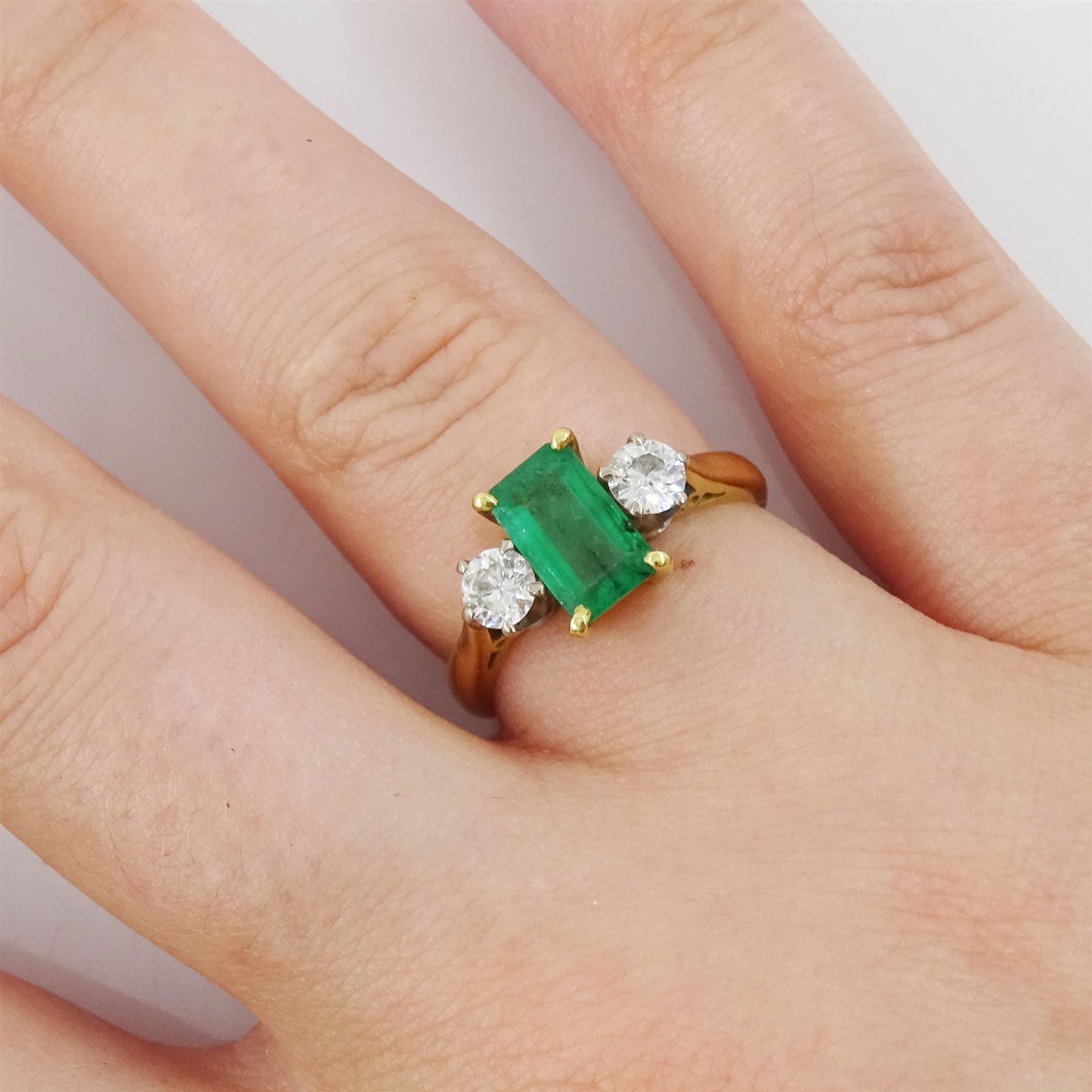 18ct gold three stone octagonal cut emerald and round brilliant cut diamond ring, Sheffield 1981, emerald approx 0.80 carat, total diamond weight approx 0.35 carat