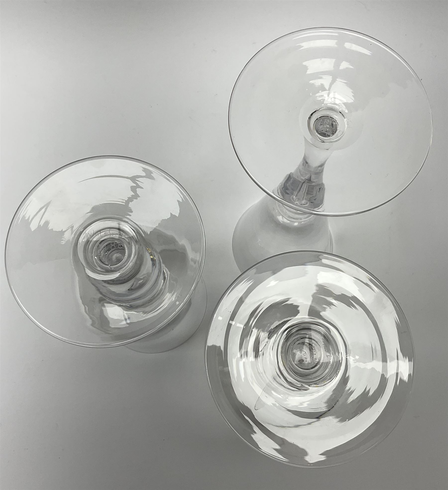 Three Whitefriars Royal Commemorative glasses, comprising two examples with bucket bowls etched with Royal ciphers and dates, upon baluster stems with internal tears and circular feet, one marked beneath W T Wilson no1080, the other G Baxter no 86; and a third example with funnel bowl also etched with Royal cipher and date, upon a baluster stem with internal tear and circular foot, marked beneath G Baxter No 218, H23.5cm.