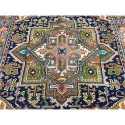 Persian Heriz indigo and rust ground rug, central geometric star medallion decorated with stylised foliate motifs, the border decorated with stylised flower heads