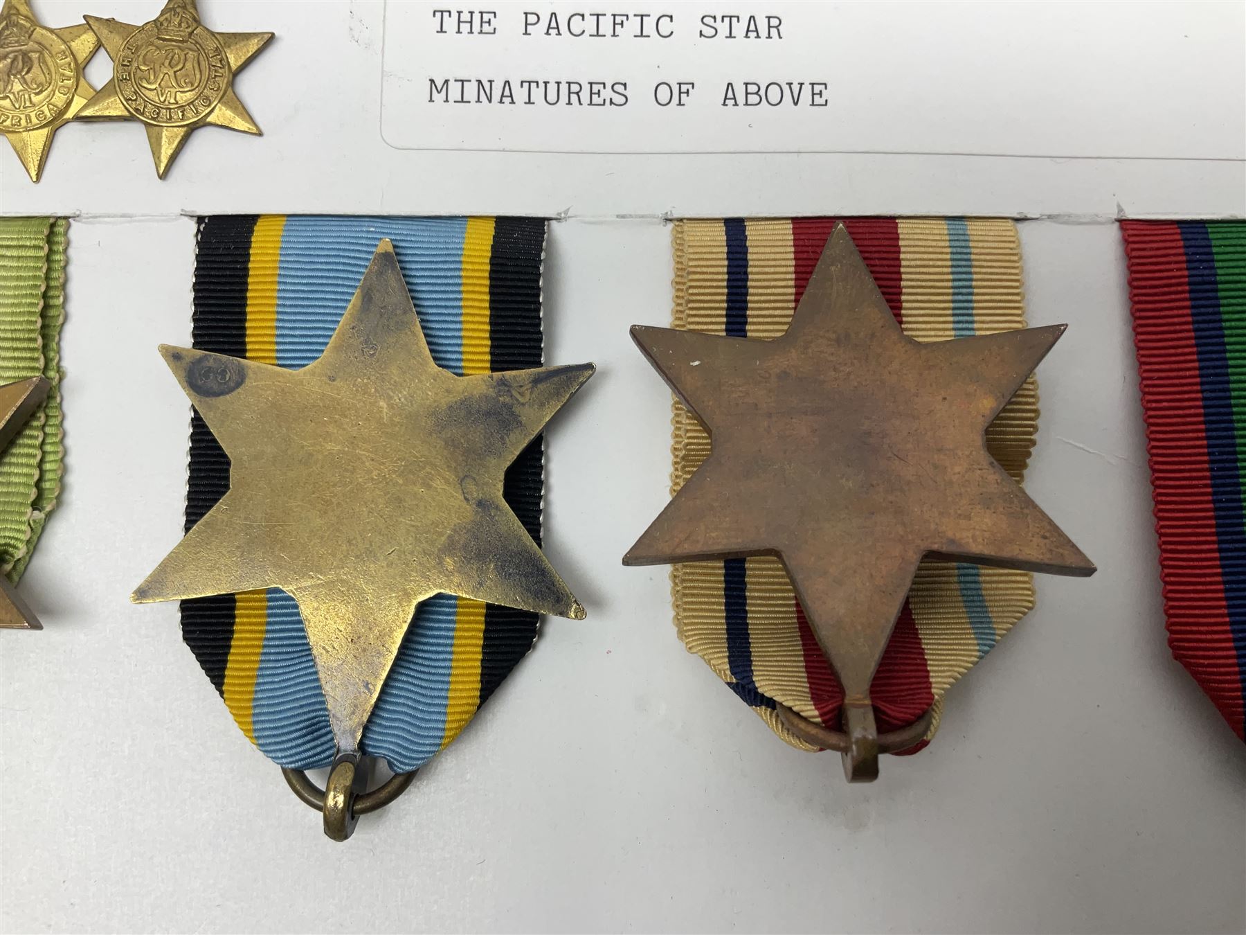 Representative display of WWII Campaign stars comprising 1939-1945 Star, Atlantic Star, Air-Crew Europe Star, Africa Star and Pacific Star; together with the corresponding group of miniatures; all with ribbons