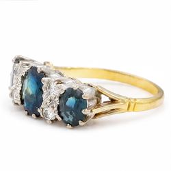 18ct gold sapphire and diamond ring, three graduating oval cut sapphires, the principal stone with two round brilliant cut diamonds set either side, London 1975, total sapphire weight approx 2.70 carat
