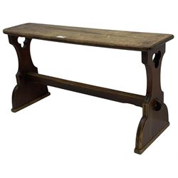 Late Victorian ecclesiastical pitch pine side table, rectangular bow-front top, on shaped end supports pierced with quatrefoils, united by pegged stretcher 