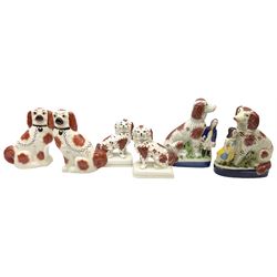 Three pairs of Staffordshire style figures, comprising pair of spaniels with queen victoria's children stood next to them on a naturalistic decorated base H31cm, pair of red and white spaniels on a plinth H22cm and another pair of spaniels H28cm.   