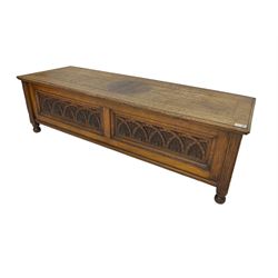 Early 20th century oak ‘bay window’ shaped blanket chest or coffer, hinged top, the front with two lunette carved panels flanked by fluted uprights, on turned feet