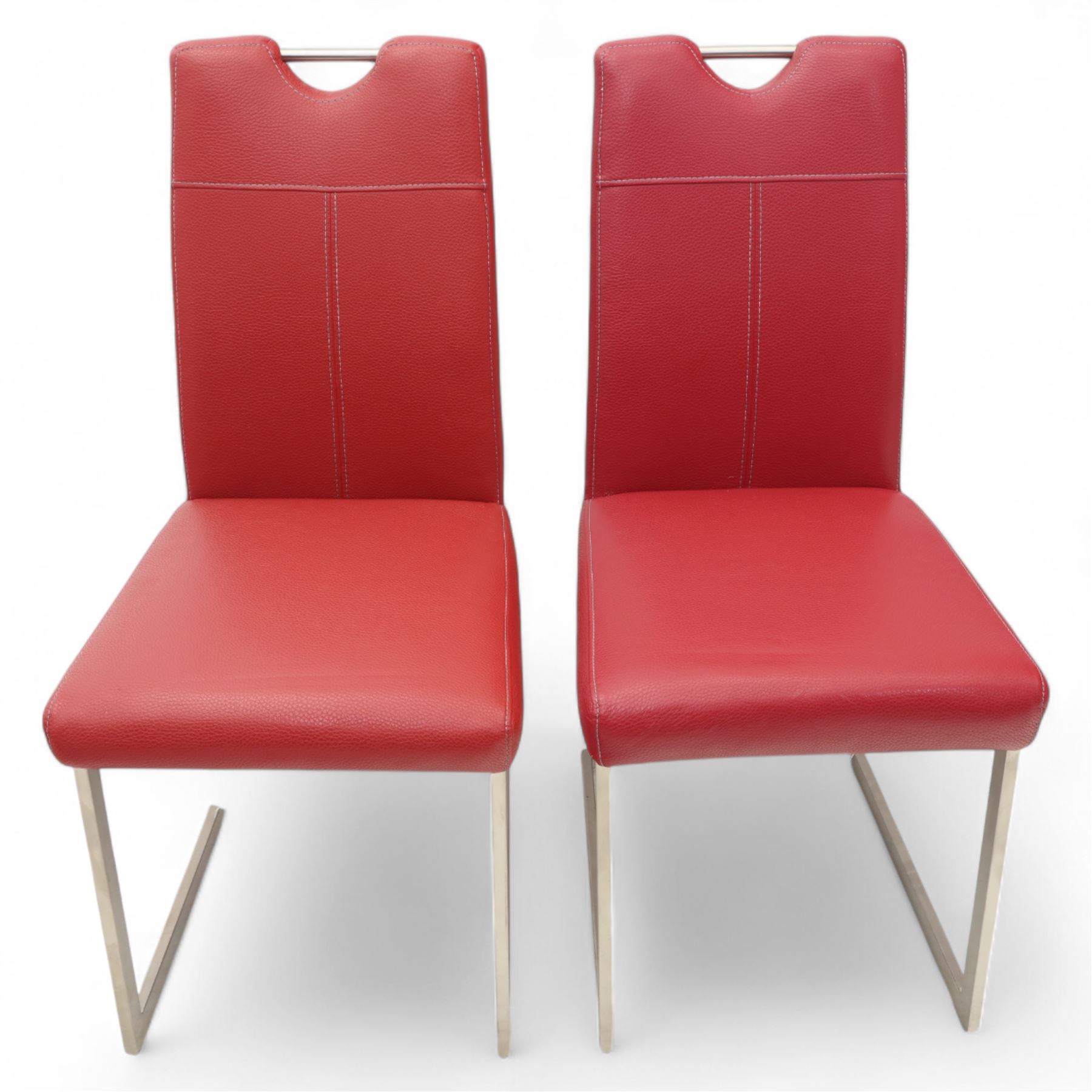 Set of seven contemporary style dining chairs, each with a high padded back and seat upholstered in faux leather on brushed steel sled bases  