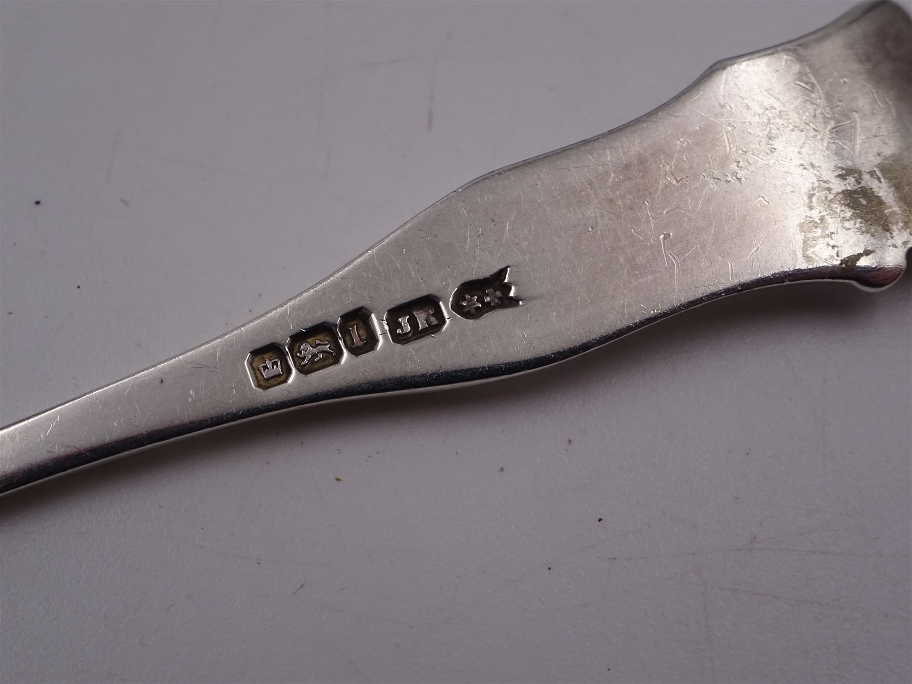 Edwardian silver cream jug, of fluted helmet form, with angular handle and upon shaped foot, hallmarked Birmingham 1905, maker's mark indistinct, together with a set of six Edwardian silver teaspoons and a pair of sugar tongs, all with scrolling embossed decoration and engraved monogram, hallmarked Joseph Rodgers & Sons, Sheffield 1903, within tooled leather fitted case, jug including handle H9cm 