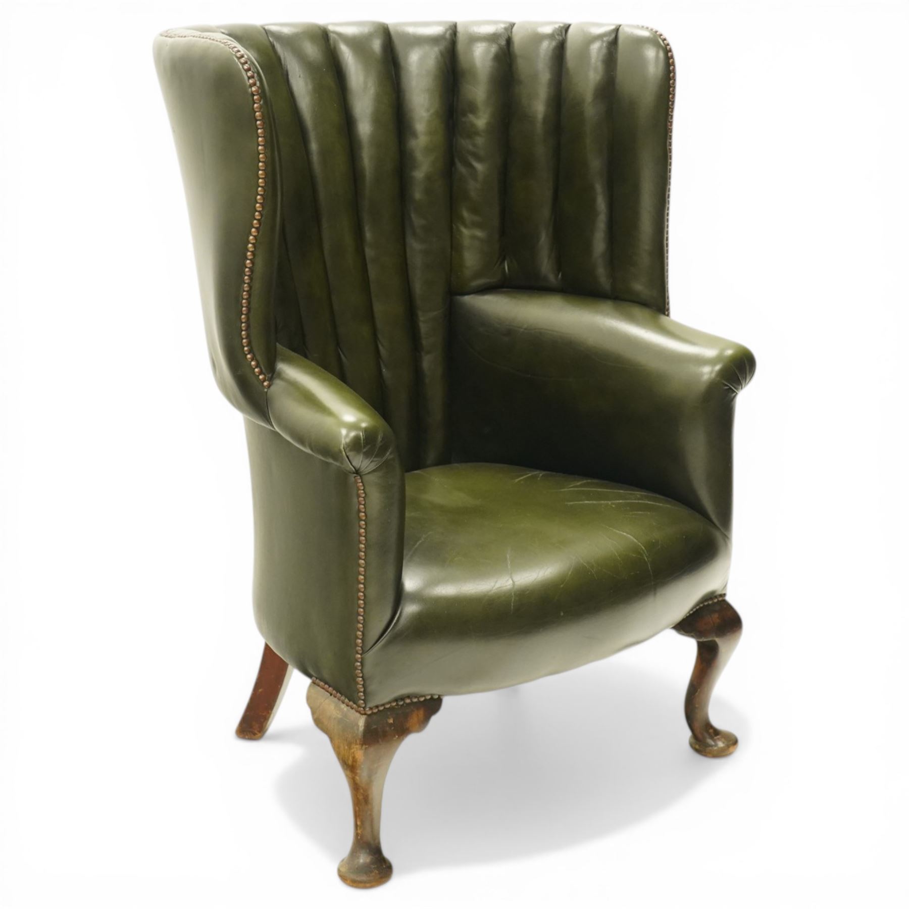 Georgian design green leather barrel-back wingback armchair, pleated upholstered back with shaped wings over scroll arms and sprung-seat, close nailed border, raised on cabriole supports terminating in pad feet