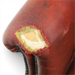 Georgian design wingback armchair upholstered in oxblood leather, the deep button upholstered back with shaped wings and out-scrolled arms, close nailhead trim to the edges, over a loose seat cushion, raised on cabriole front supports terminating in claw and ball feet