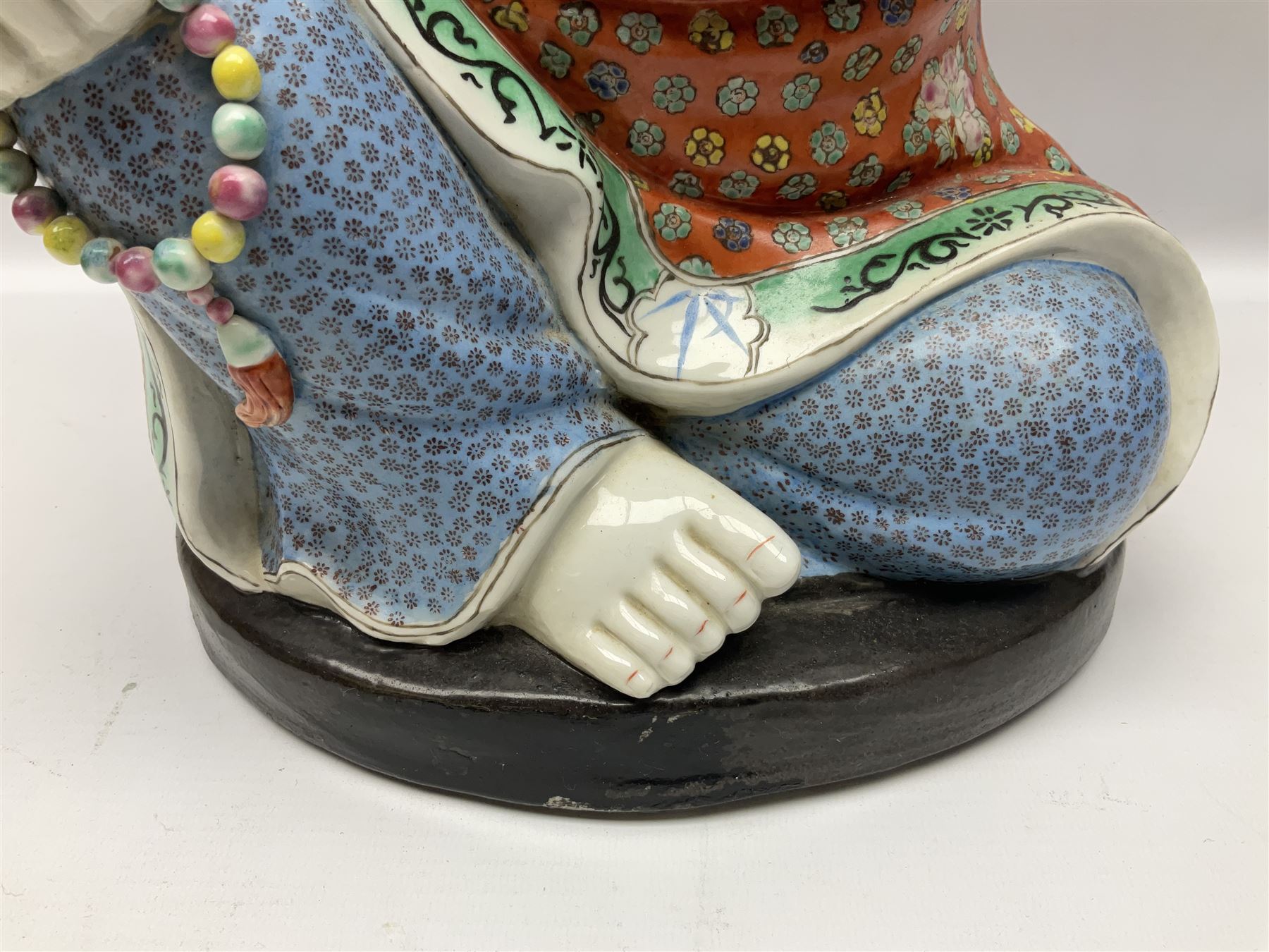 Tall Chinese polychrome figure of Guanyin (Guan Yin), the Goddess of Mercy and compassion, the Bodhisattva modelled seated and holding a rosary donning elaborate floral robes and beads, with four character seal marks beneath, H53cm