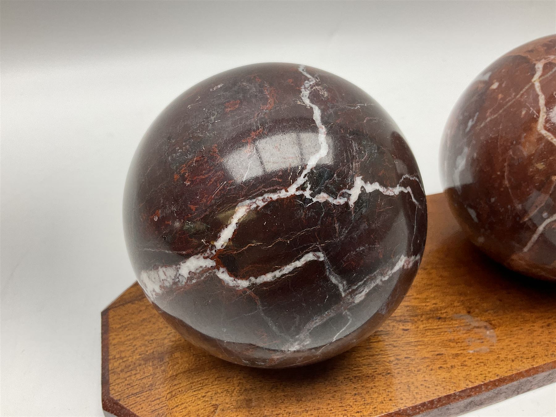 Set of three marble spheres on a elongated octagonal wooden base, H12cm