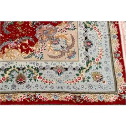Fine Persian silk inlaid crimson ground Tabriz rug, the shaped field decorated with a central foliate pole medallion filled and surrounded by finely knotted floral motifs and trailing foliage, the cyan guard stripe with bold festoons and palmette motifs