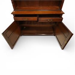 Late Victorian tall walnut open bookcase on cupboard, projecting cavetto cornice over reeded and fluted uprights moulded with roundel motifs, flanking two adjustable shelves, the base fitted with two drawers over panelled cupboards, carved with oakleaf and acorn motifs and grapevines, on bracket feet