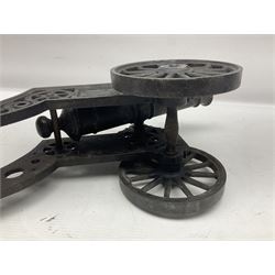 Victorian cast-iron and steel signal cannon, approximately half-inch bore, with 23cm ringed barrel and cylindrical trunnions, on a cast iron carriage with two twelve-spoked wheels and guilloche pierced swept back support, L43cm overall