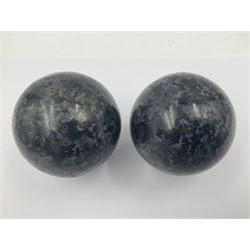 Pair of indigo gabbro spheres, upon carved wooden bases, D8cm