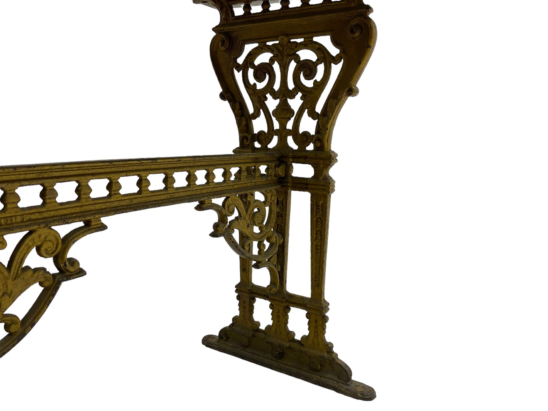 Pair of 19th century cast iron entrance tables, rectangular marble top over ornate gilt bases with scrolling foliate design and sledge feet, united by balustrade stretcher with scroll spandrels