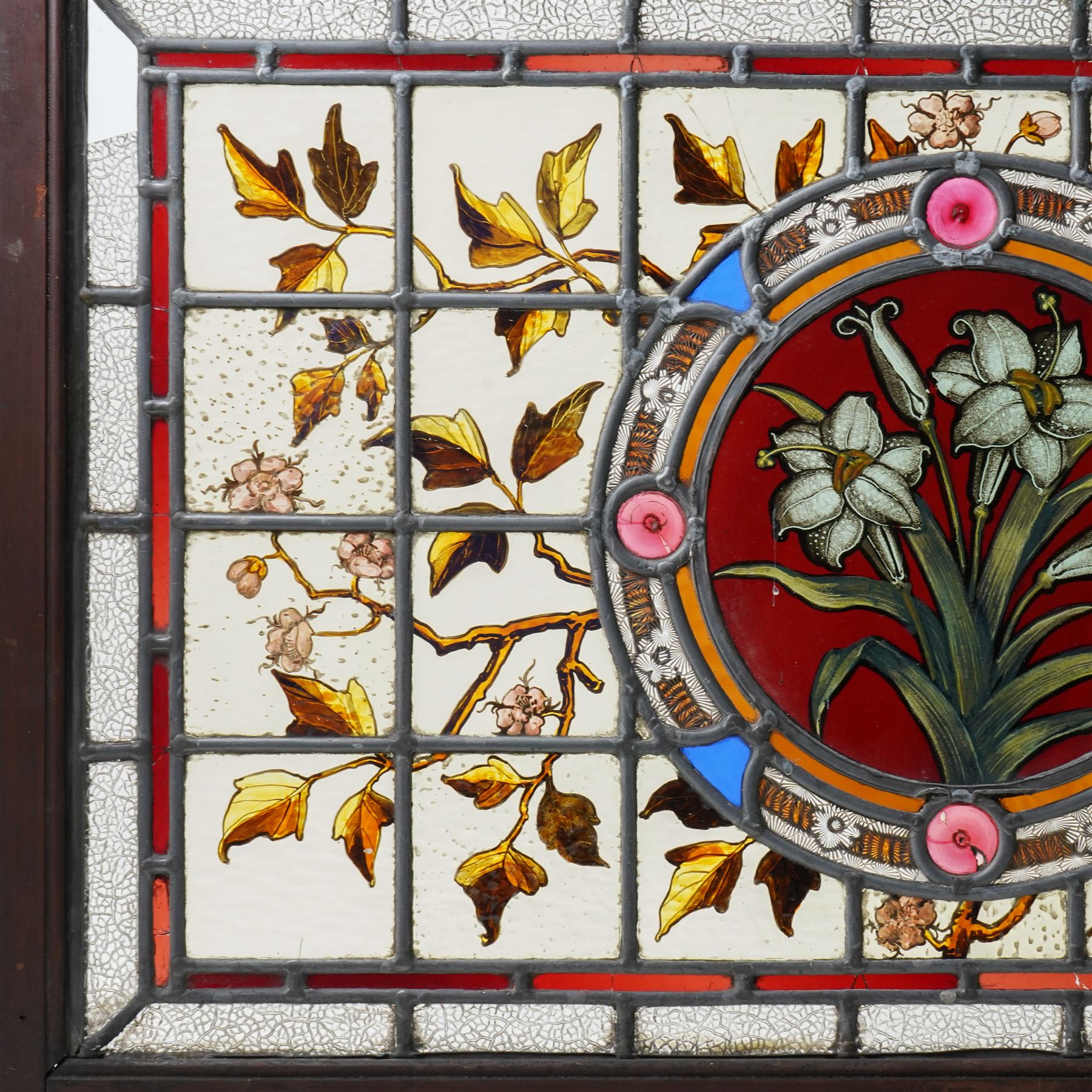 Victorian Aesthetic movement stained glass leadlight window panel, the central panel hand painted with a sprig of daffodils, the surrounding panels profusely decorated with branches and leaves, overall 62cm x 84cm 