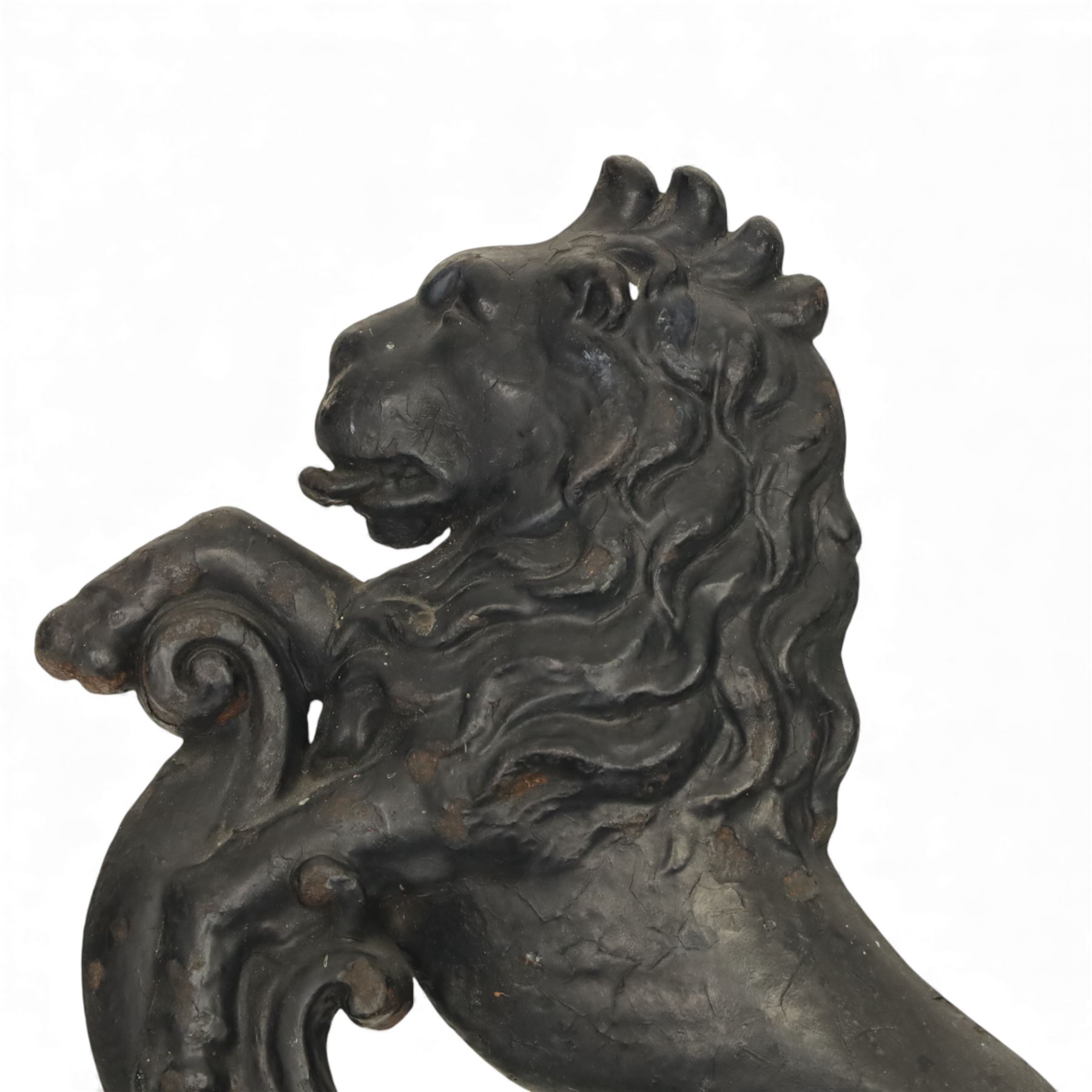 Victorian cast iron figural doorstop in the form of a lion, depicted seated with curled tail and detailed mane, raised foreleg resting against a scroll motif, set on an integral stepped base with moulded edges and foliate ornament