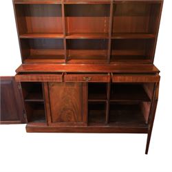 Early 20th century mahogany open bookcase, with reeded upright divisions and adjustable shelves, over a cupboard base fitted with three frieze drawers and three panelled doors, on plinth base