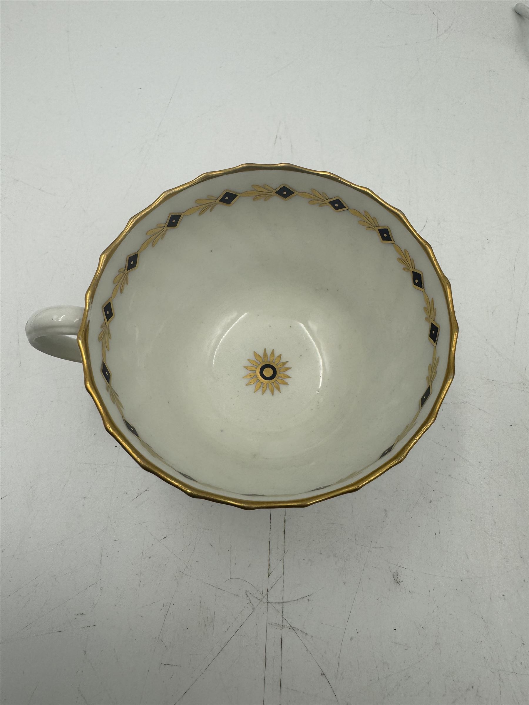 18th century Caughley blue and white sparrow jug, decorated in the Mother and Child pattern, circa 1780-1790, with underglaze C mark beneath, H9cm, together with a Worcester coffee cup, circa 1785 painted with floral sprays in underglaze blue and gilt, with crescent mark beneath, and a Caughley trio of tea cup, tea bowl and saucer, each of moulded wrythen fluted form and decorated with gilt and blue sprigs and bands, each with crescent mark beneath, (5)