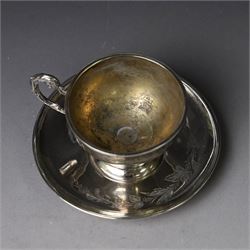 German silver cup and saucer, both with engraved foliate decoration, stamped 800, the saucer with crescent and crown mark