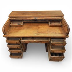 Globe Wernicke - Oak roll top desk, fitted with nine drawers, oak tambour roll top revealing a fitted interior, with single frieze drawer, flanked by four drawers to each pedestal, on a plinth base