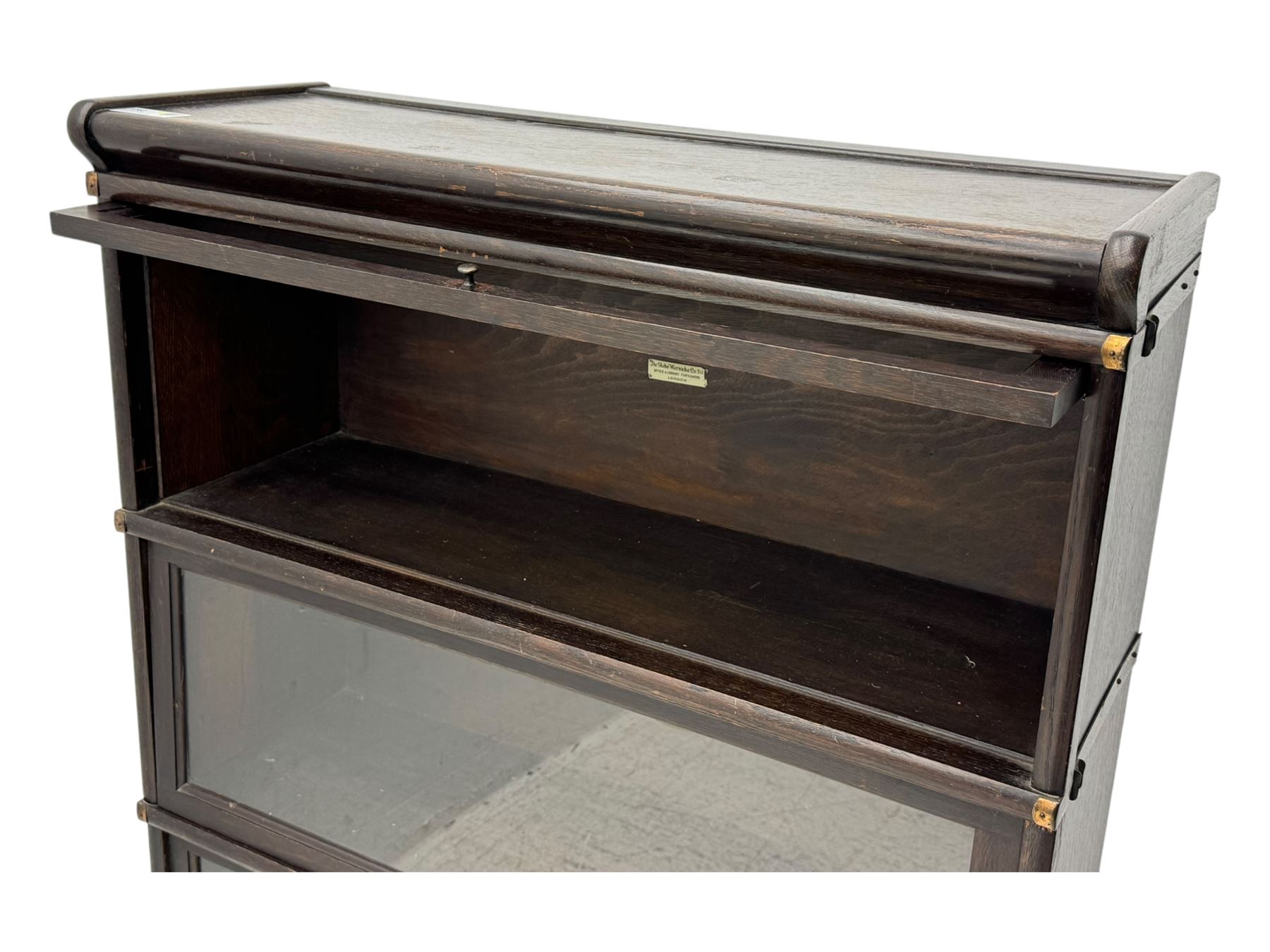 Globe Wernicke - early 20th century oak three-tier stacking library bookcase, three glazed sections enclosed by hinged and sliding doors, raised above a single lower drawer with metal drop handles