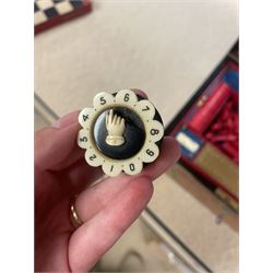 19th century walnut and brass bound games compendium box, painted to enhance the grain, of rectangular form, the hinged opening cover with rounded sides, central brass cartouche with engraved lion crest, and brass riveted straps, opening to reveal a red leather and blue silk lined compartmented interior, with fold-down games board, and lift-out tray containing playing cards, ebony turned dice towers, white and red stained bone draughts, and chess pieces, ivory dice, and ivory and ebony whist markers, and brass bezique board, cribbage board and markers, H15cm W32cm D24cm
This lot has been registered for sale under Section 10 of the APHA Ivory Act