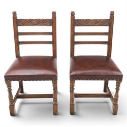 Craftsman made set of four solid oak dining chairs with leather seats, with carved cresting rail, on red leather seats with studded trim, raised on block and turn supports united by H-stretcher